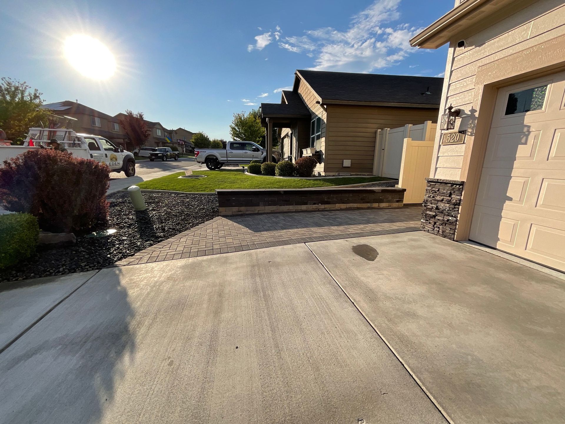 A concrete driveway leading to a house with a garage door.