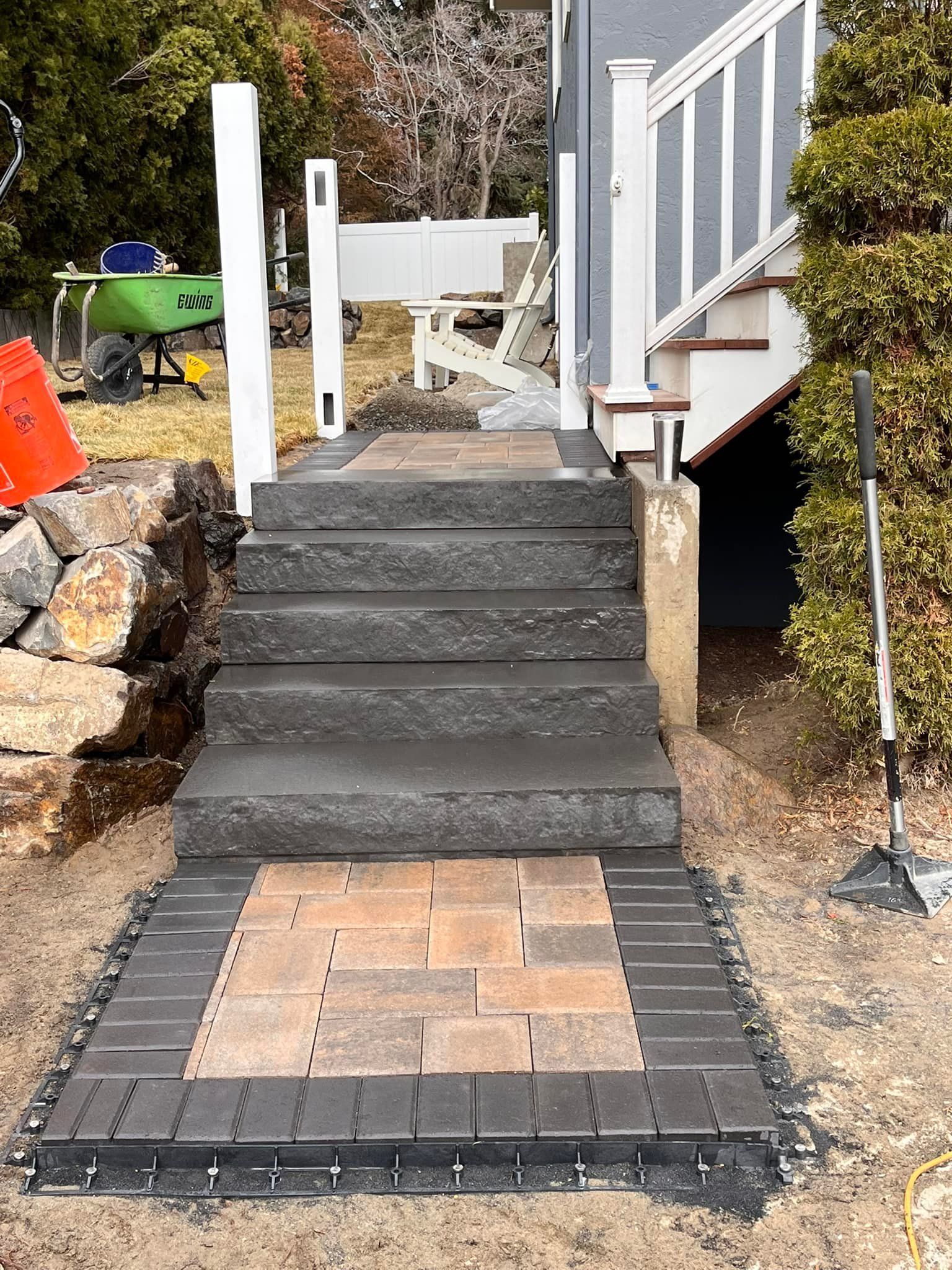 A set of stairs leading up to a deck with a brick walkway.