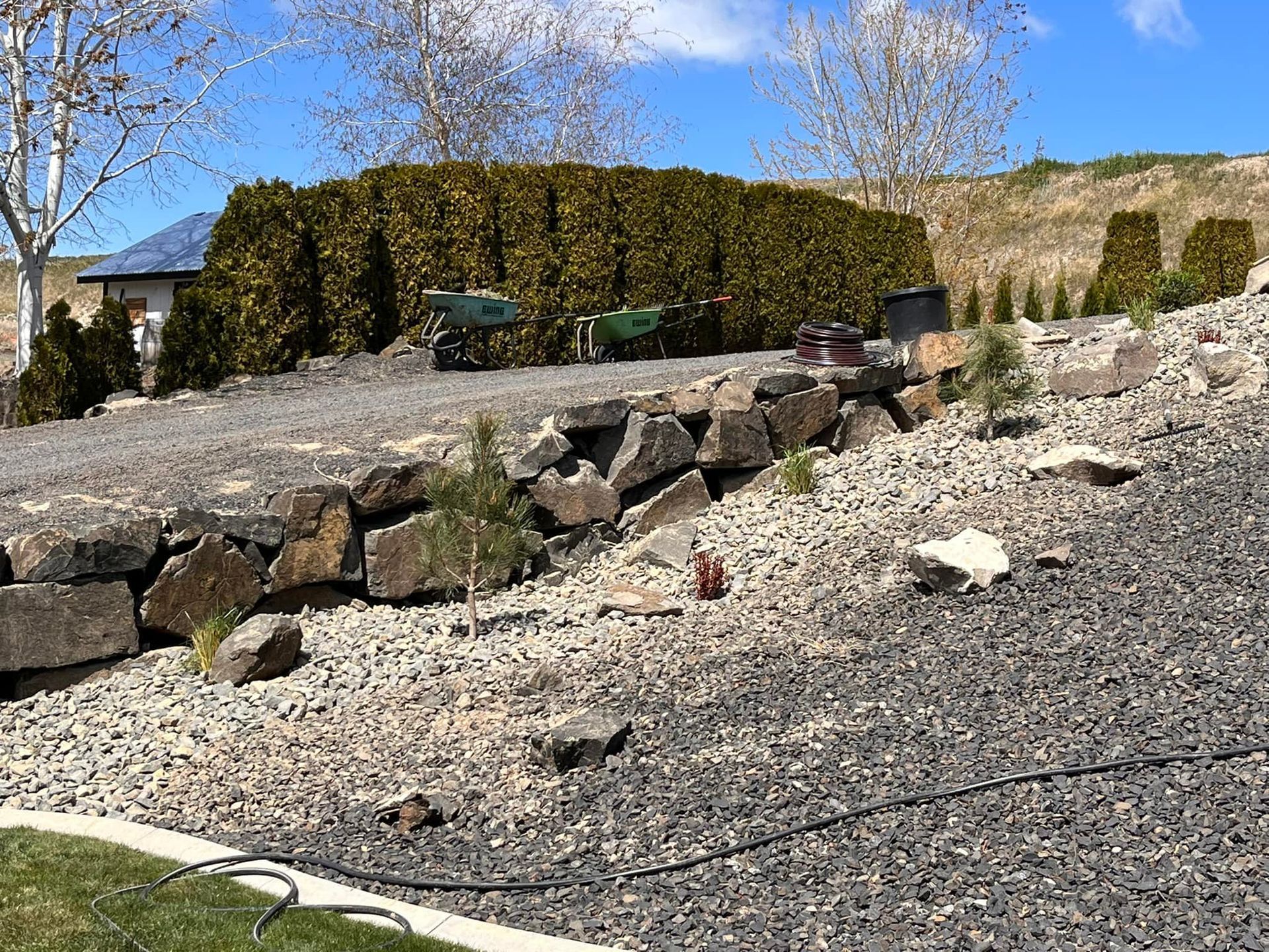 A gravel driveway with a house in the background
