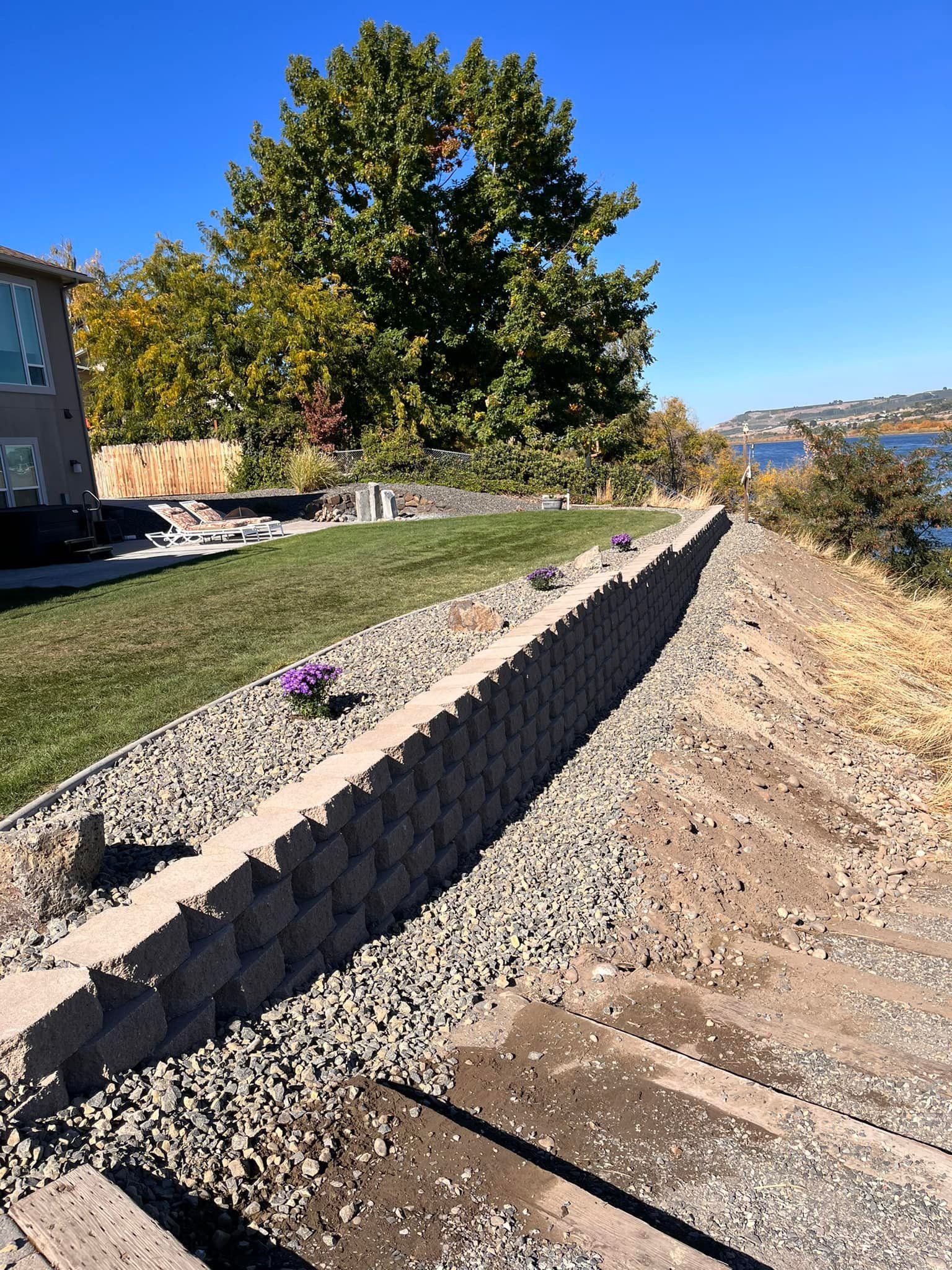 A stone wall is being built on the side of a road.