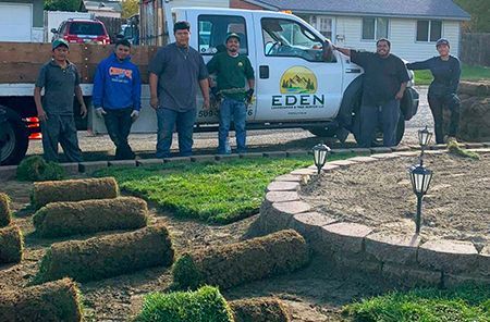 A group of people standing in front of a truck that says eden.