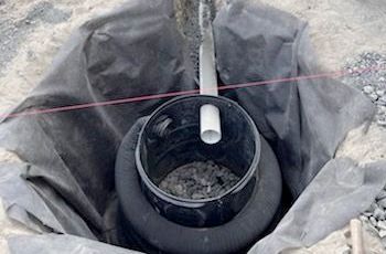 A hole in the ground with a pipe in it.