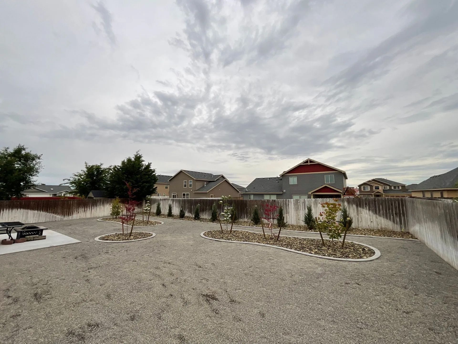 A gravel driveway with a picnic table in the middle of it