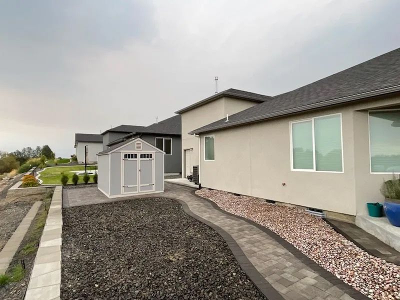 There is a shed in the backyard of a house.