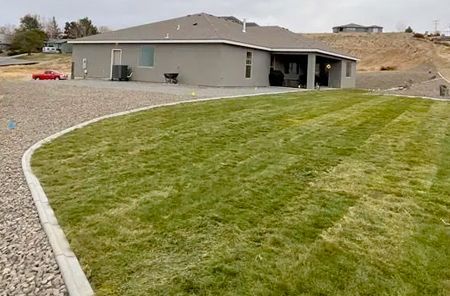 A house with a lush green lawn in front of it.