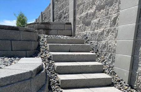 A set of stairs leading up to a stone wall.