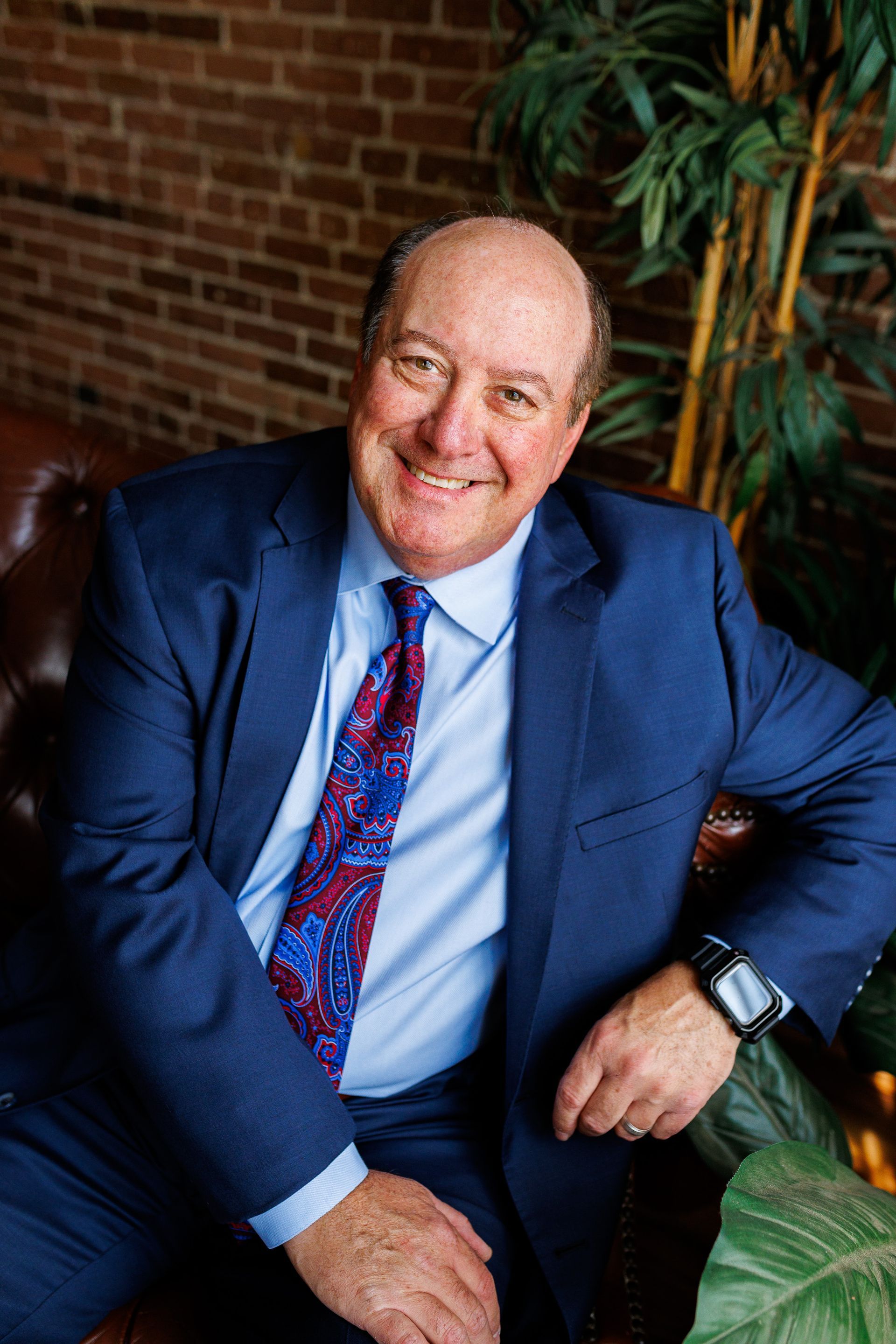 Photography MA -A man with a beard and glasses is standing with his arms crossed and smiling.