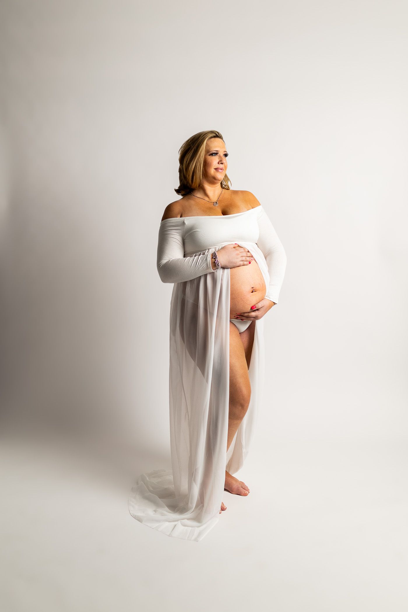 A man and a pregnant woman are embracing during a maternity photo session
