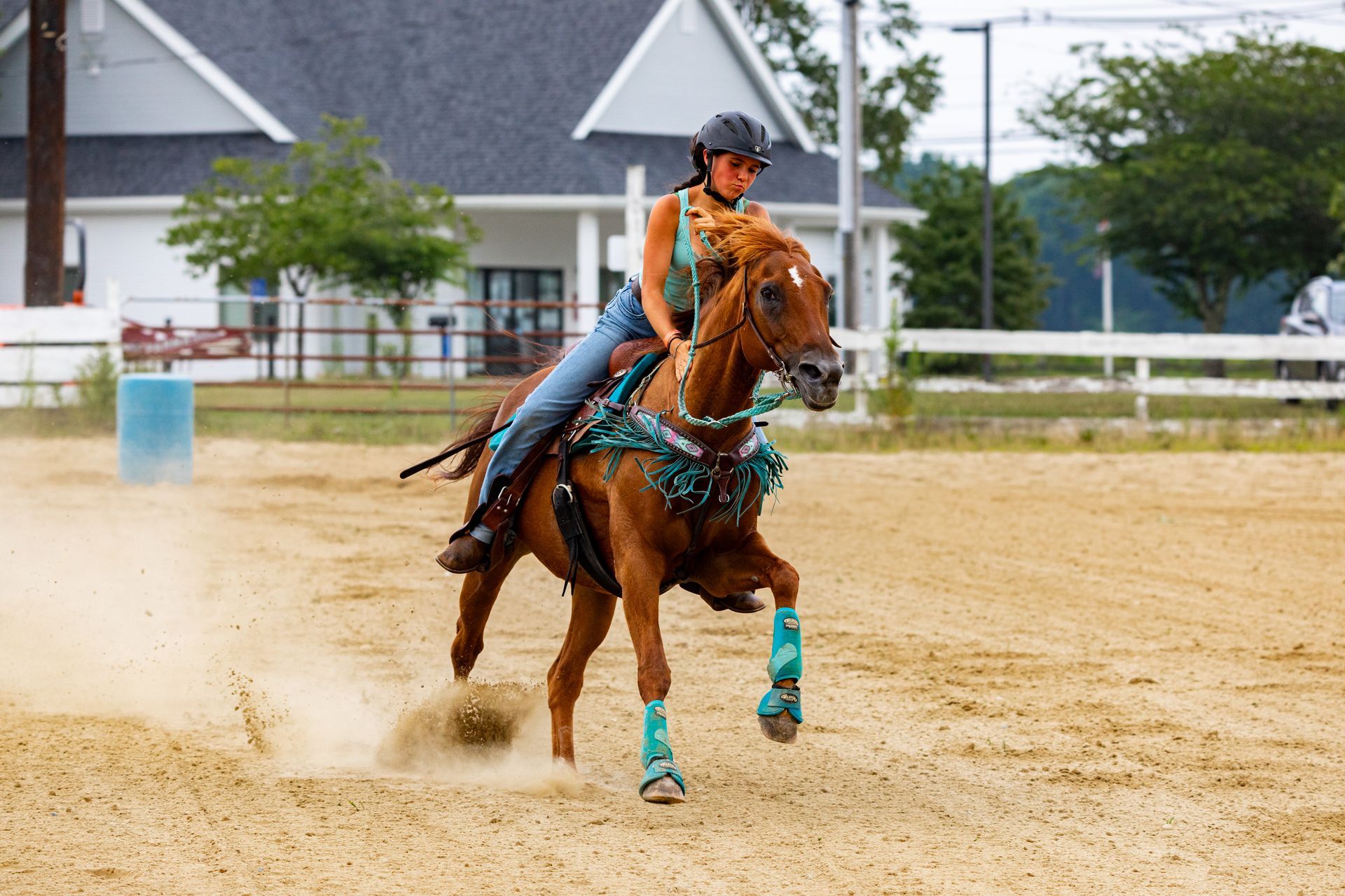 A woman is riding a brown horse in a dirt field.