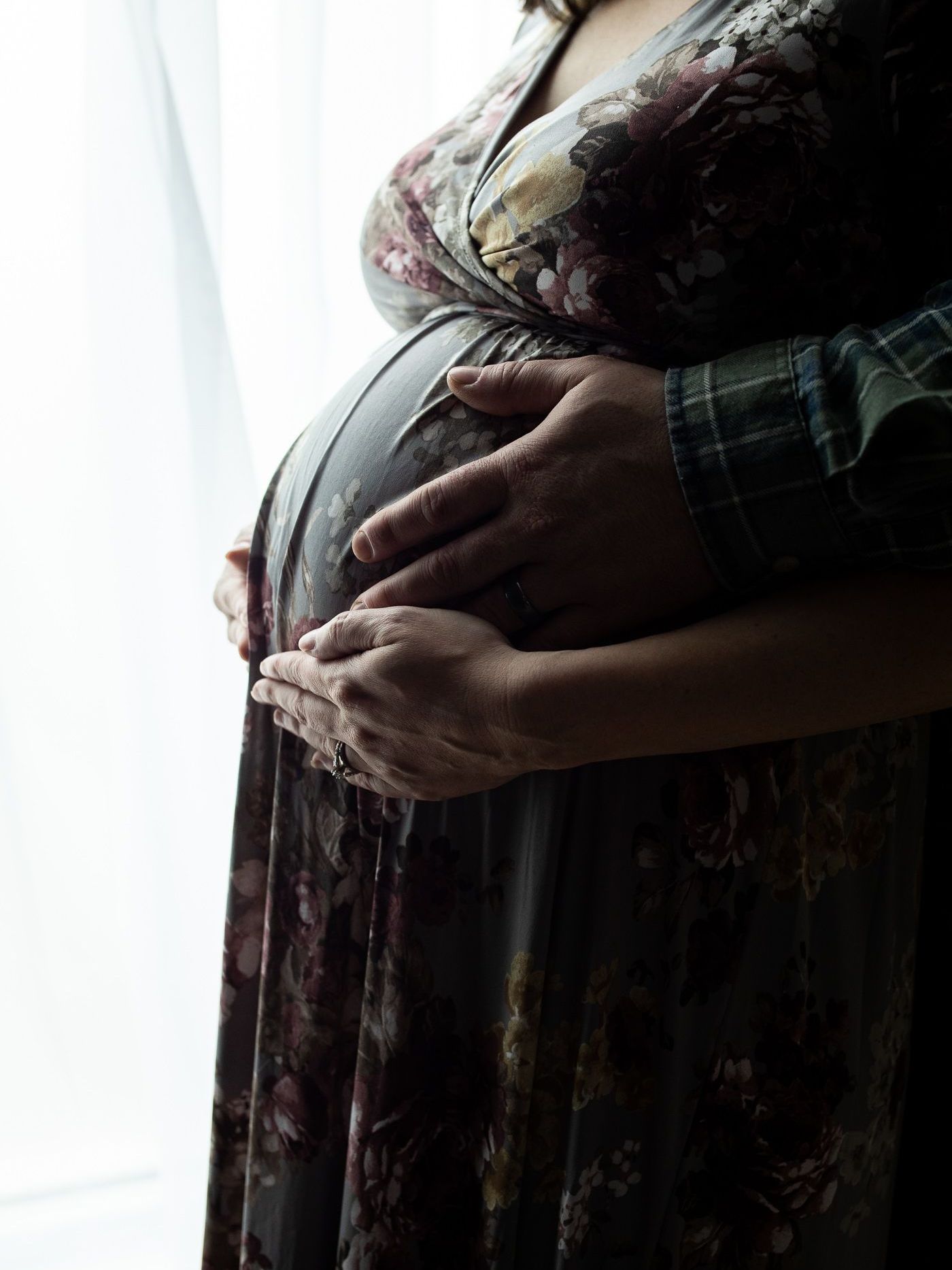 A man is holding a pregnant woman 's belly.