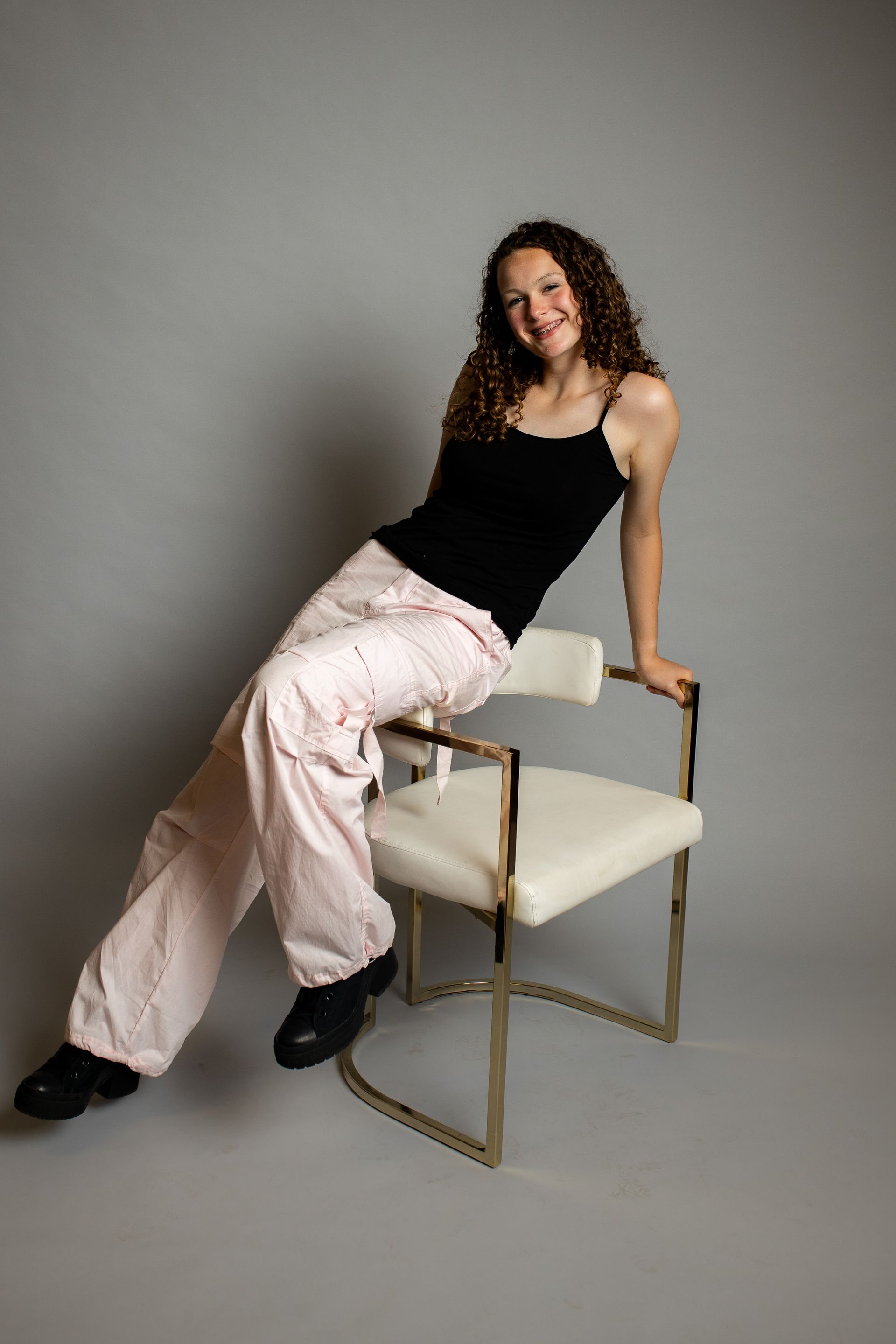 A woman is sitting on a chair with her legs crossed.