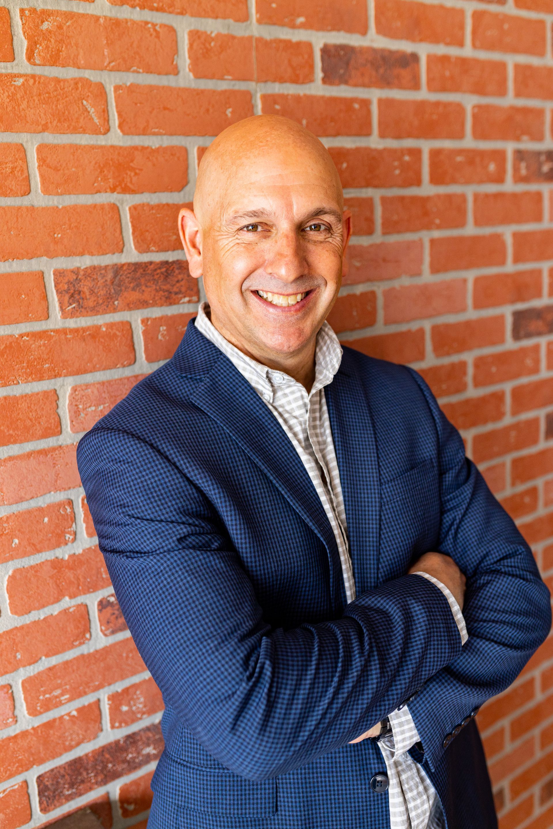 Business portrait man in blue suit and white  shirt with brick background