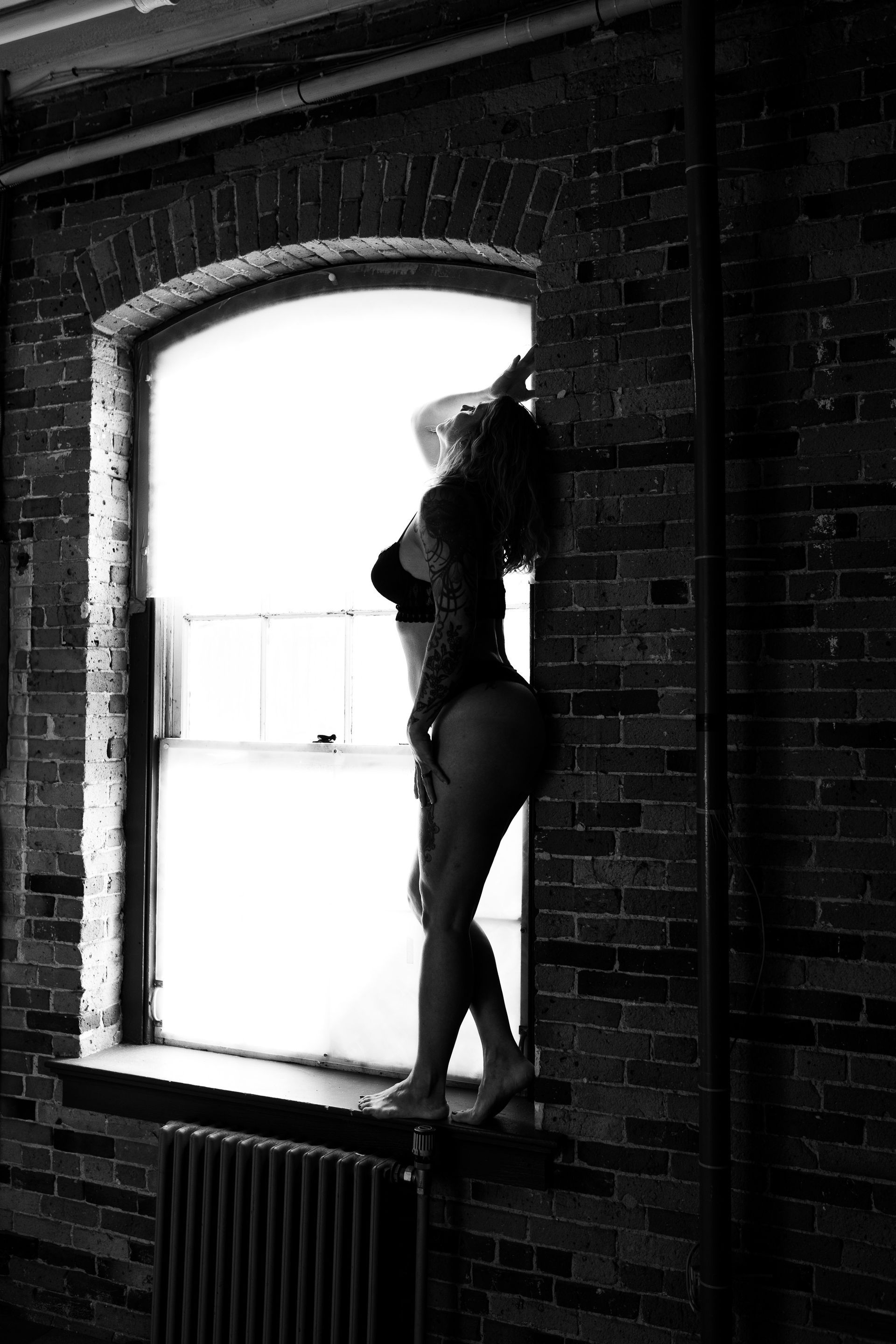 Beautiful woman posing in a window for boudoir photos 