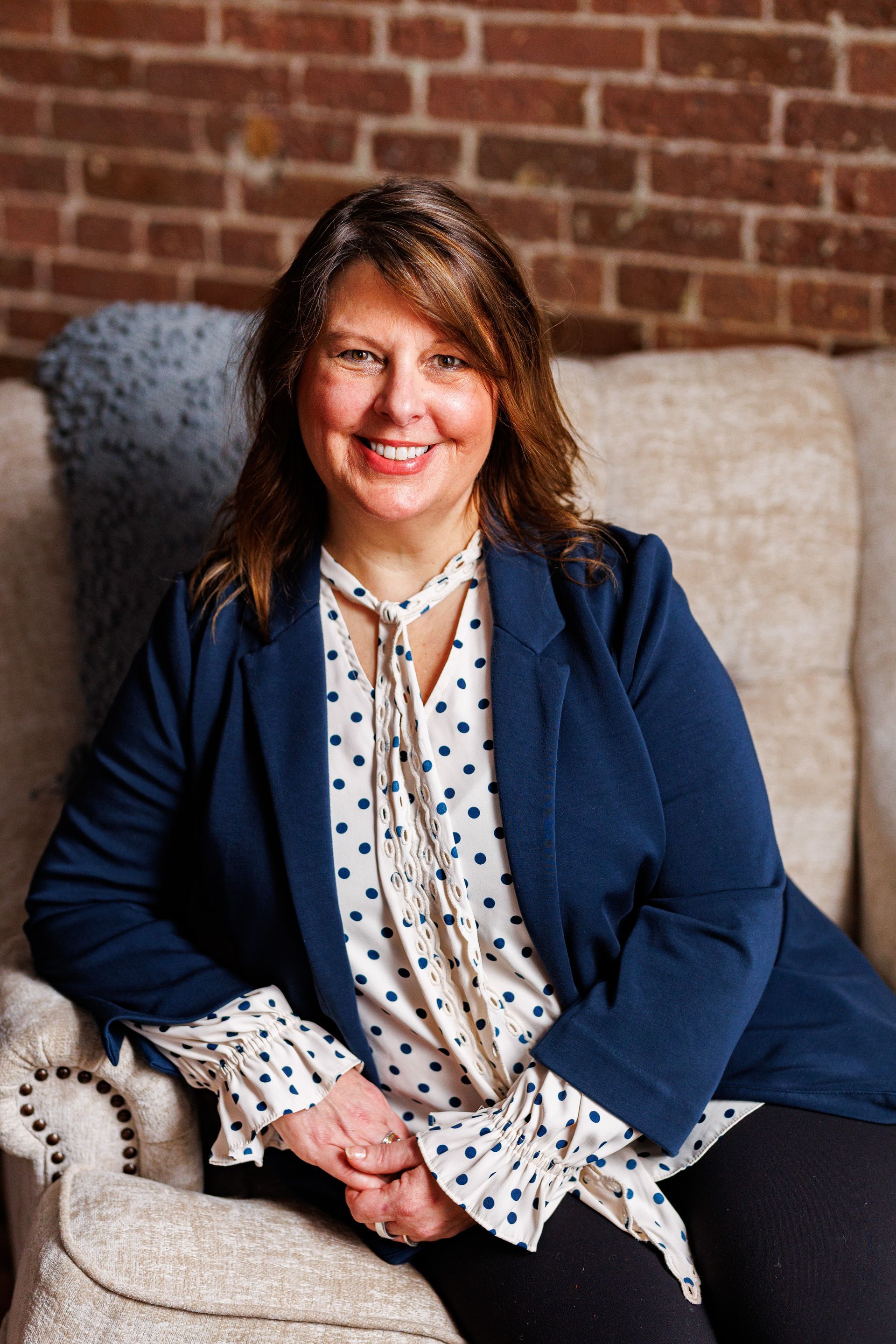 Business portrait business woman in a white shirt with polka dots and a blue blazer