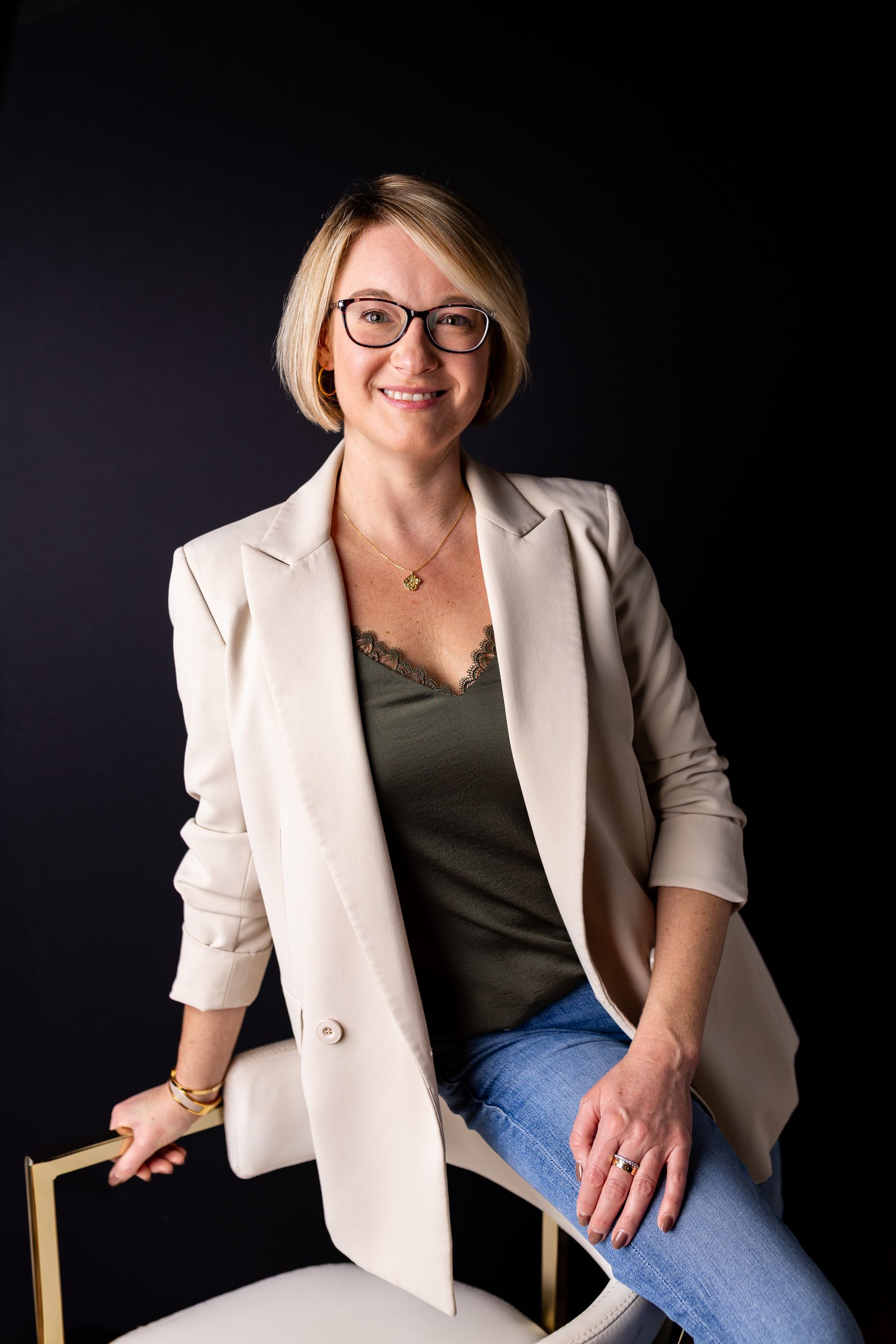 Business portrait woman in a green top and white blazer