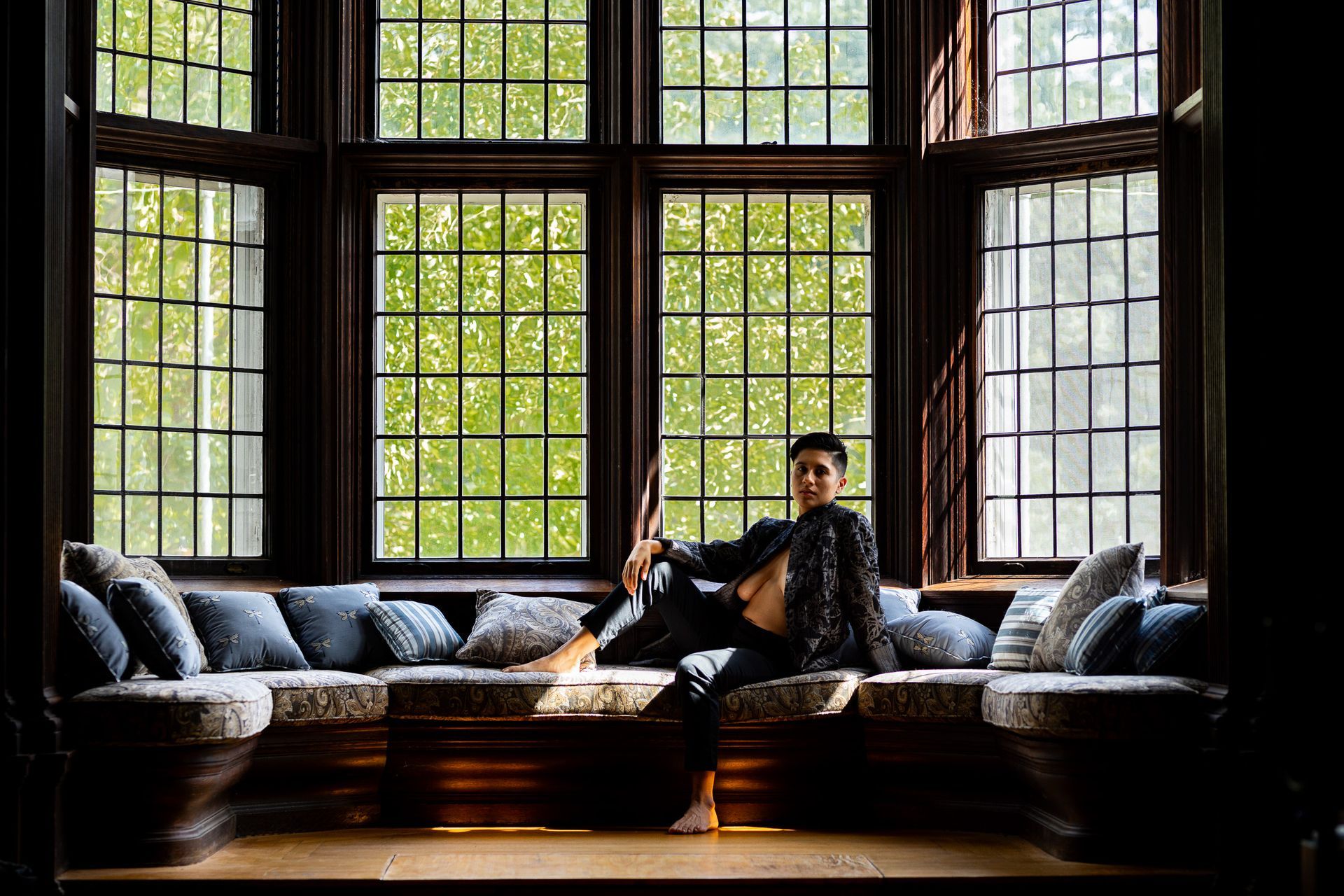 Non-binary model posing for intimate photos wearing a jacket and slacks