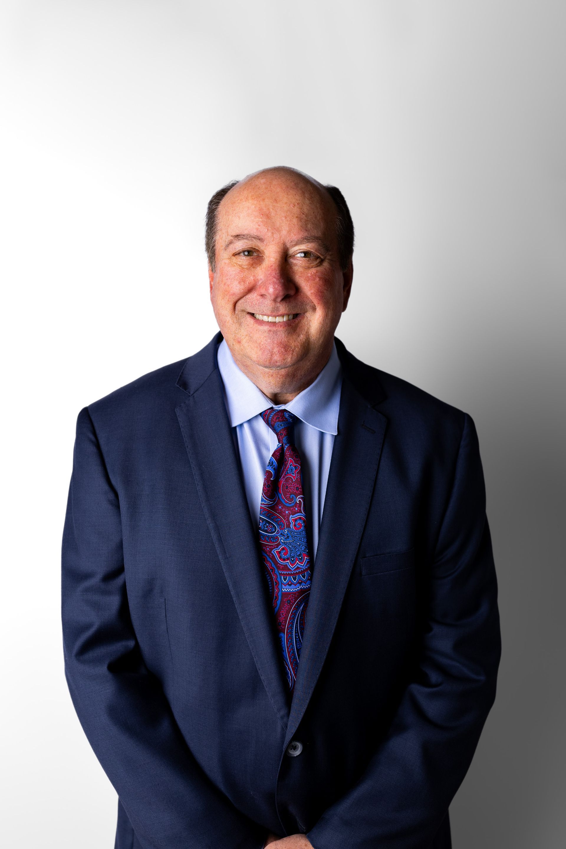 A man in a suit and tie is smiling for the camera.