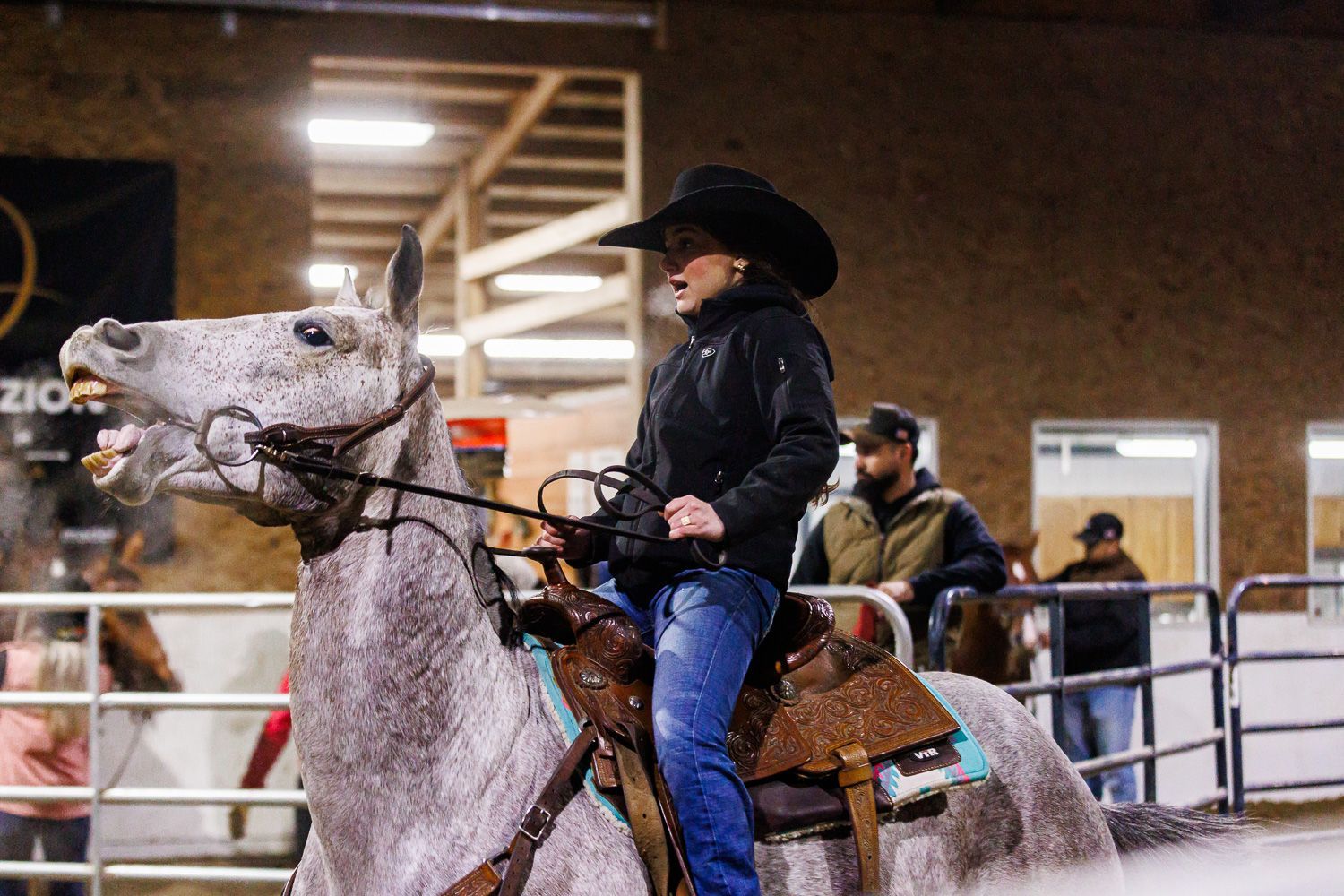 A man in a cowboy hat is riding a horse.