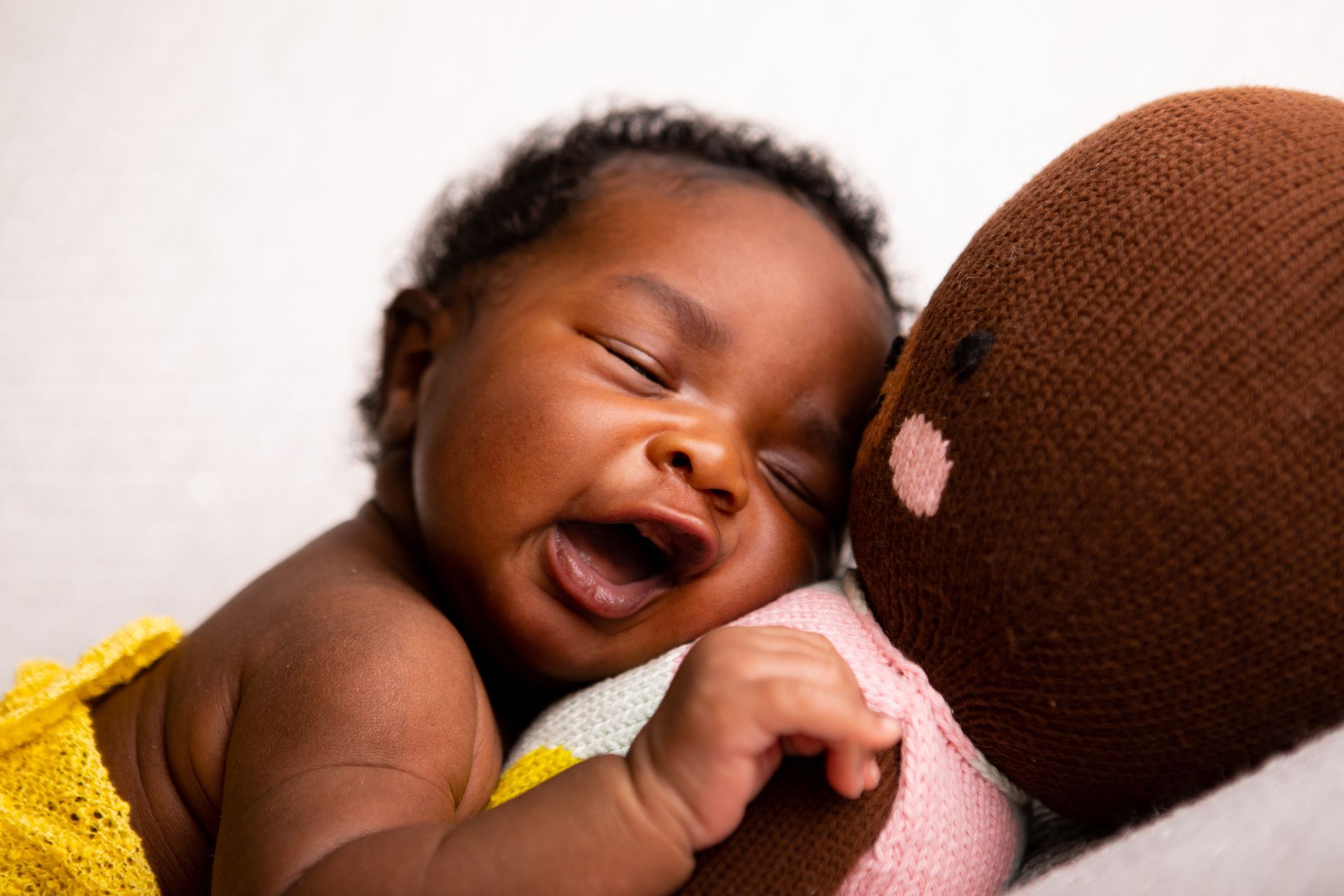 Birth photography - A woman with glasses is holding a newborn baby in a hospital bed
