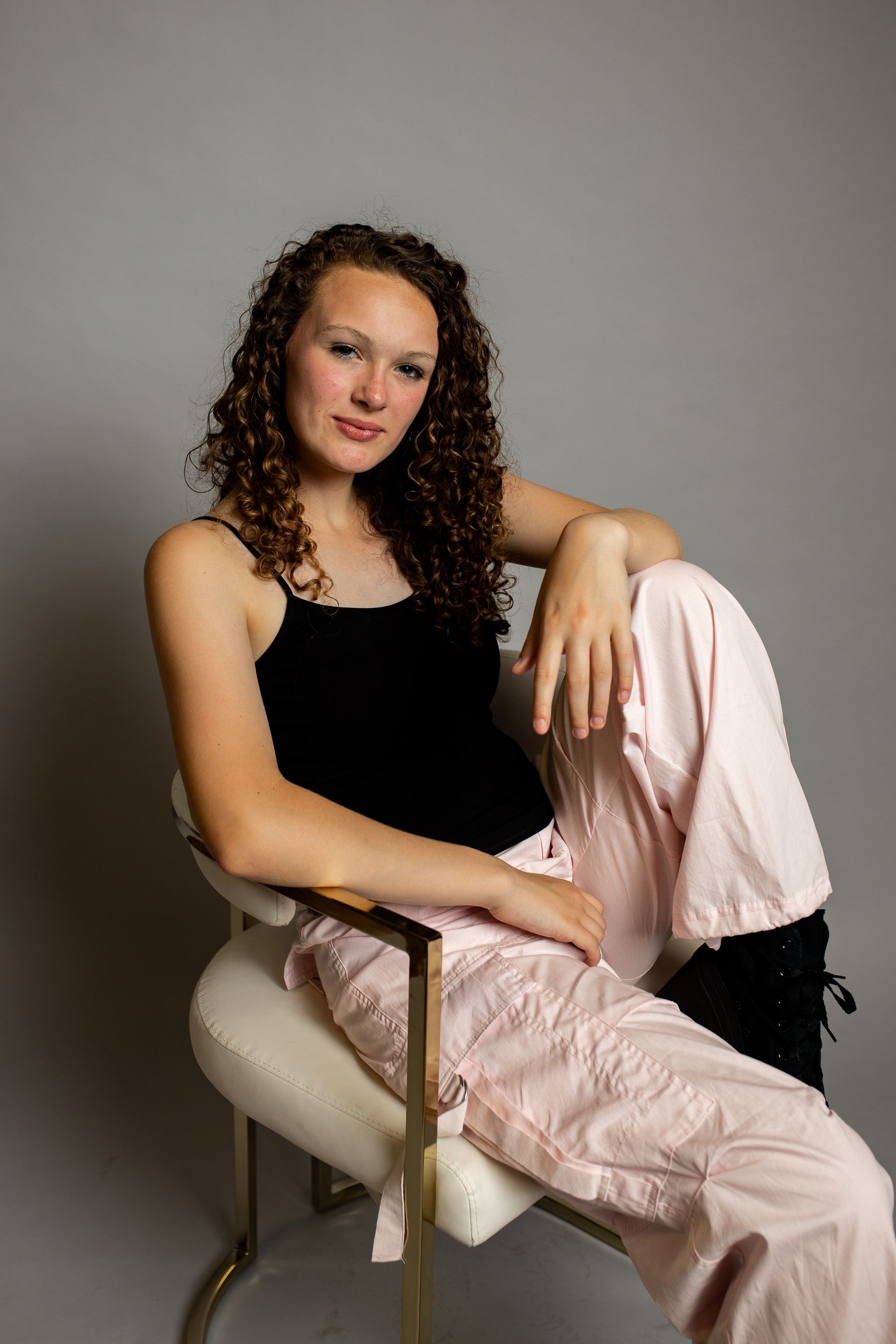 A woman is sitting in a chair with her legs crossed.