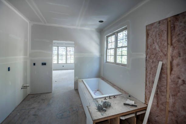A bathroom under construction with a bathtub and a window.