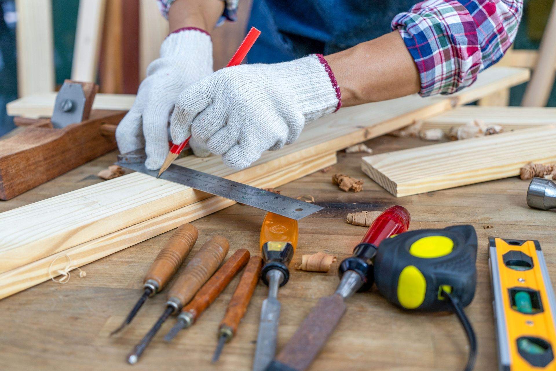 A person is measuring a piece of wood with a ruler.