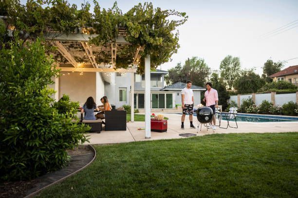 A group of people are having a barbecue in their backyard.