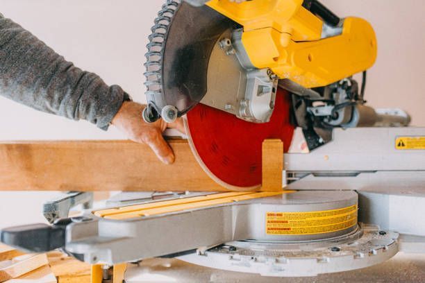 A person is cutting a piece of wood with a circular saw.