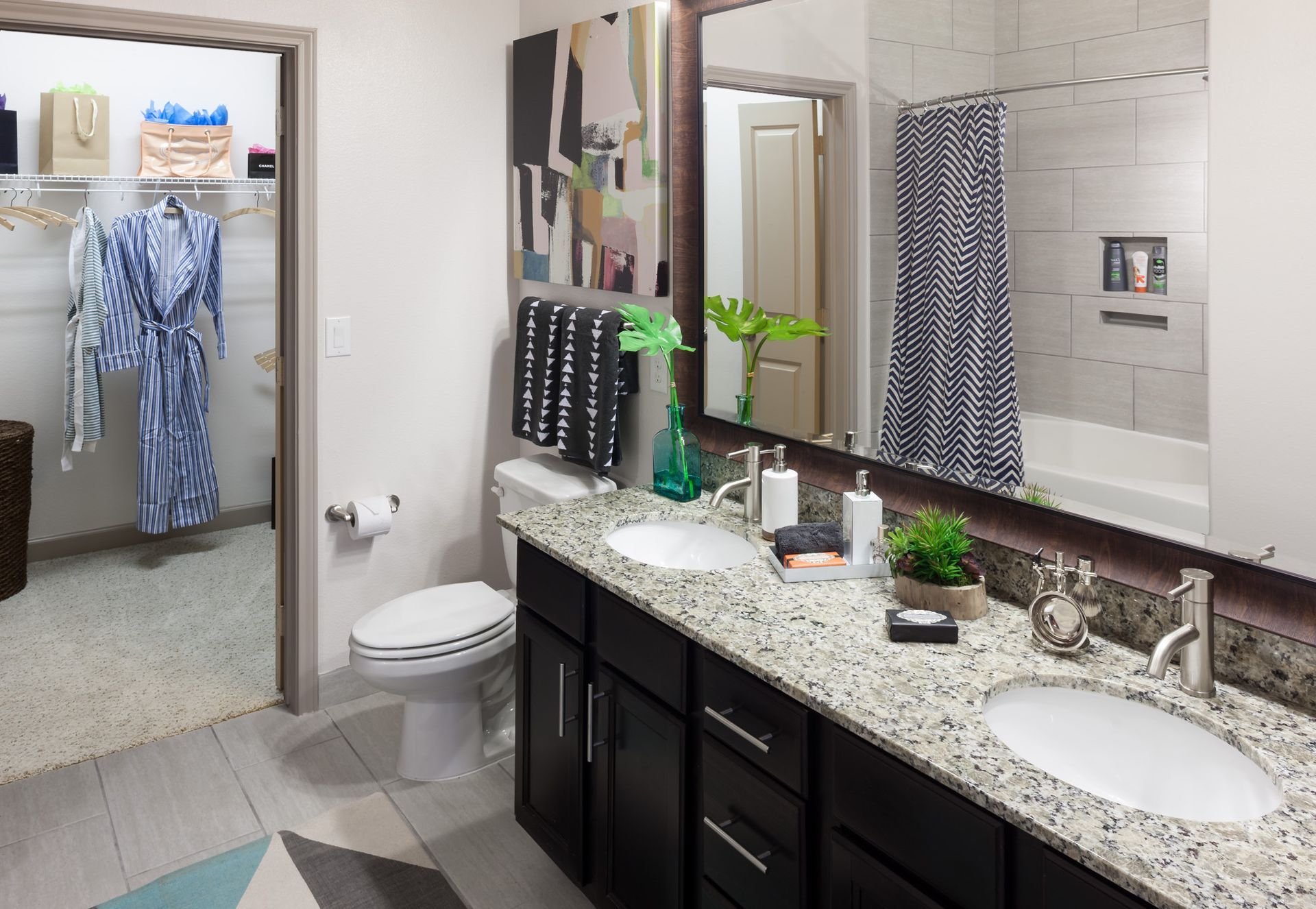 Bathroom vanity with two sinks and granite countertop, with a closet visible in the doorway.