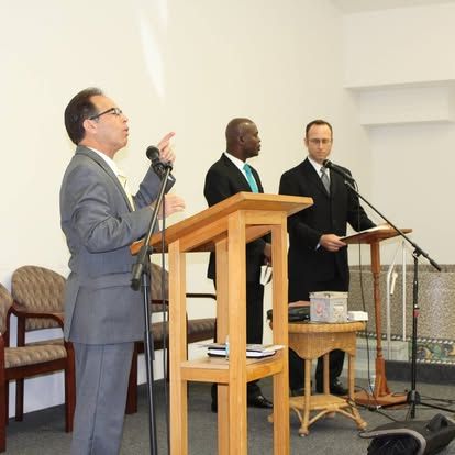 A man in a suit is giving a speech at a podium