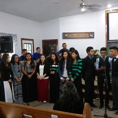 A group of people standing in front of microphones in a church