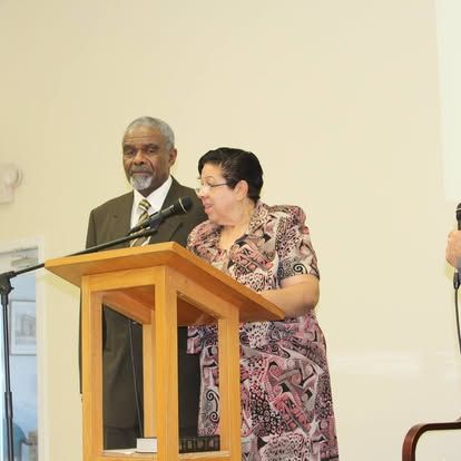 A man and a woman are standing at a podium speaking into microphones.