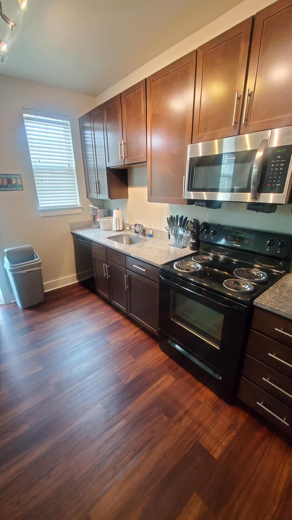 A kitchen with stainless steel appliances and wooden cabinets.