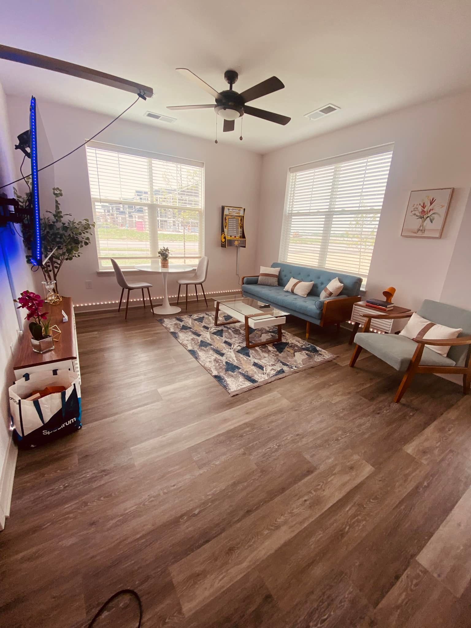 A living room with a couch , chairs , and a ceiling fan.