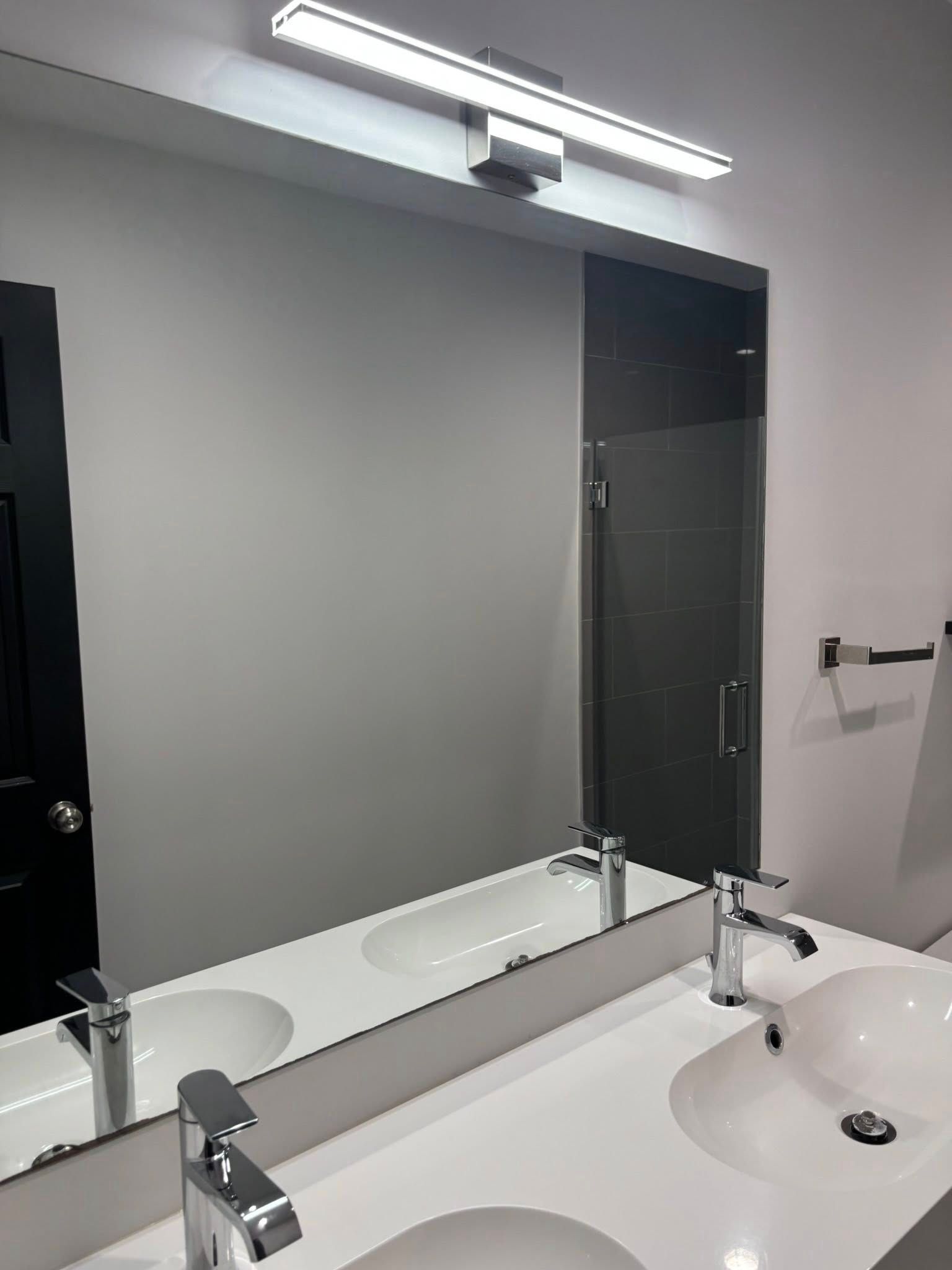 A bathroom with two sinks and a large mirror