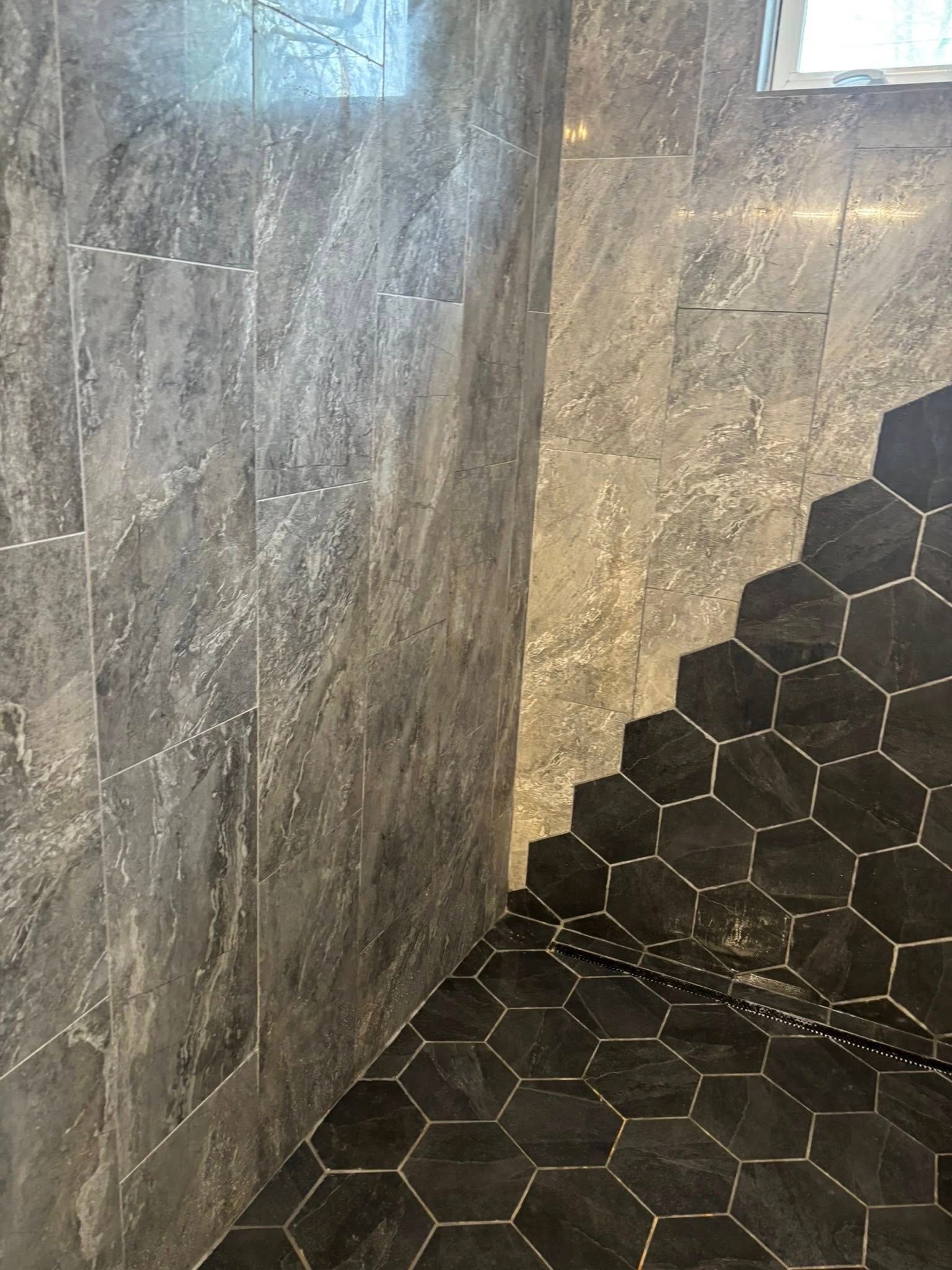 A bathroom with black tiles on the floor and walls.
