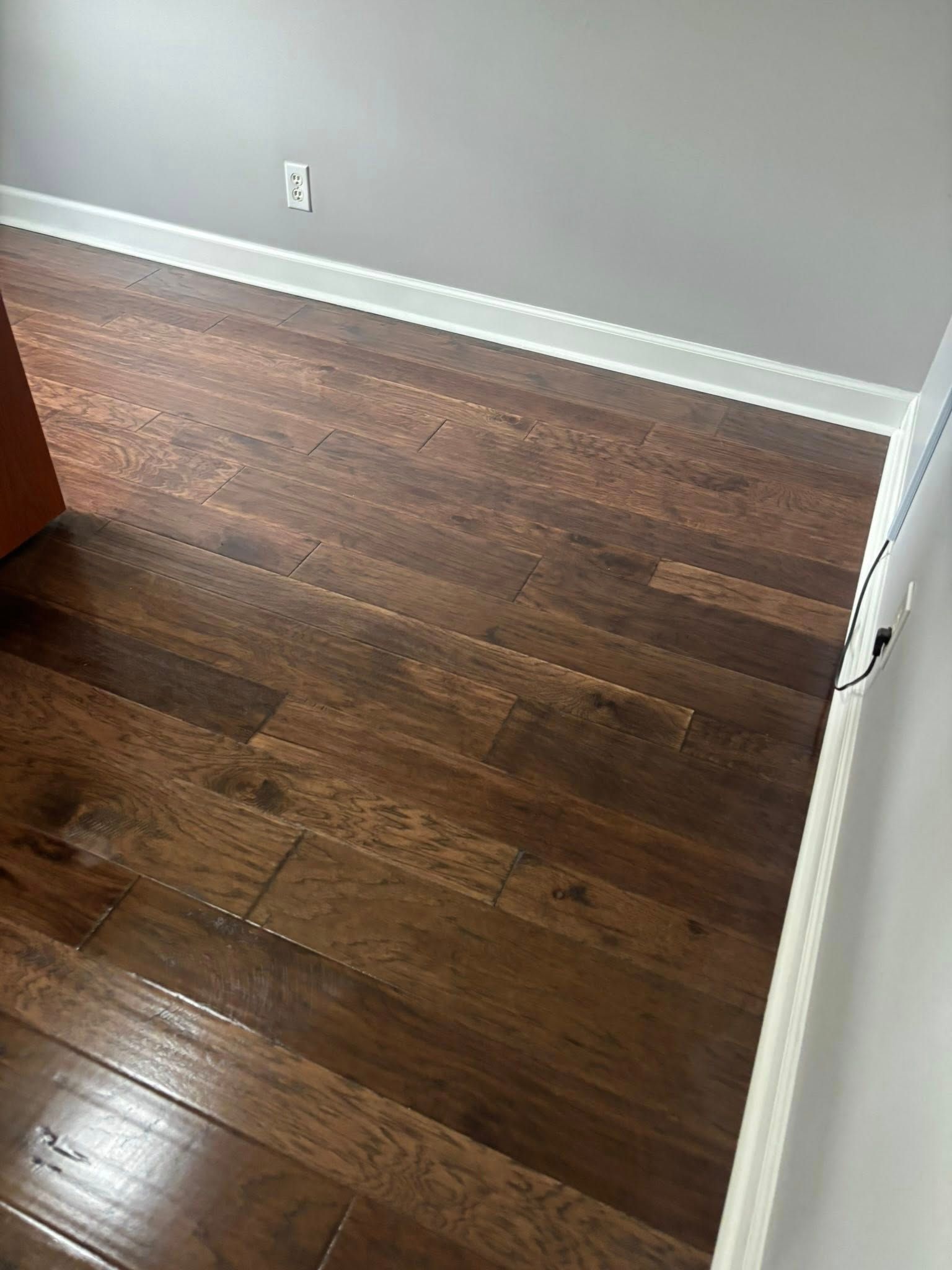 A bedroom with hardwood floors and gray walls.