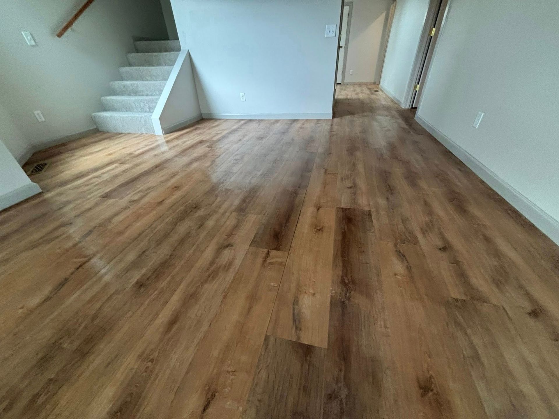 A living room with hardwood floors and stairs.