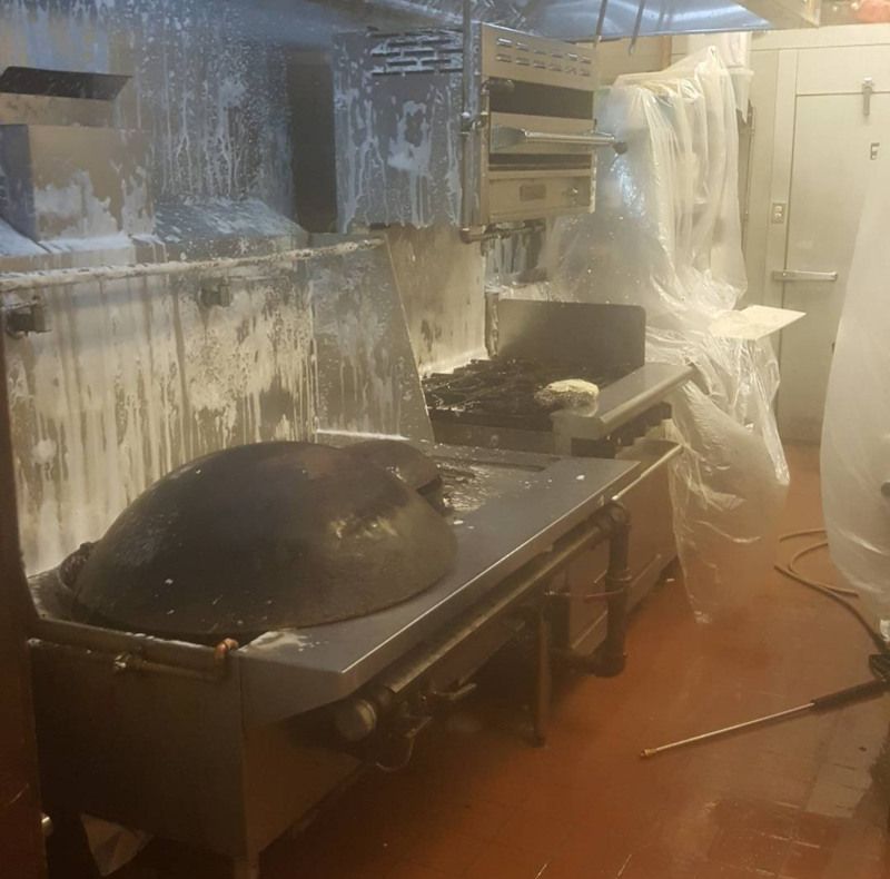 Kitchen splattered with white foam or food, dishes and equipment overturned, suggesting a messy cleanup aftermath