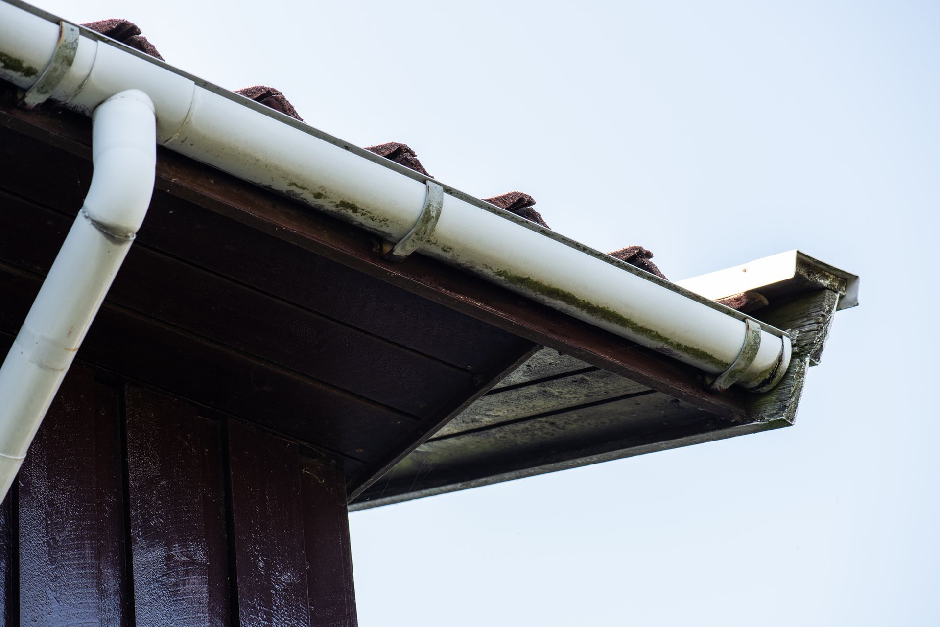 A close up of a gutter on the side of a building