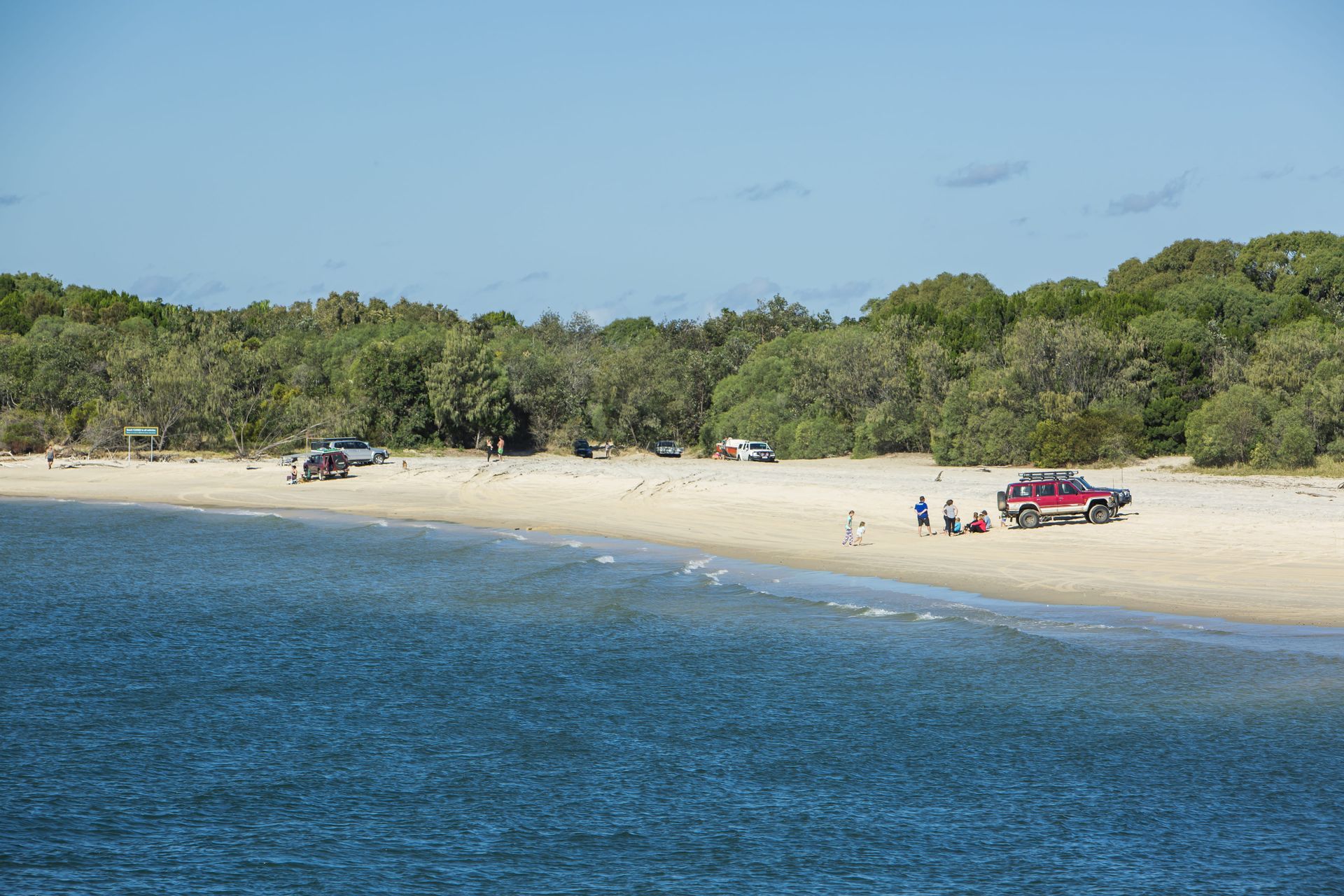 Beach With White Sand, Blue Water, Trees, and Parked Vehicles — B&D Auto Group & Towing in Bowen, QLD