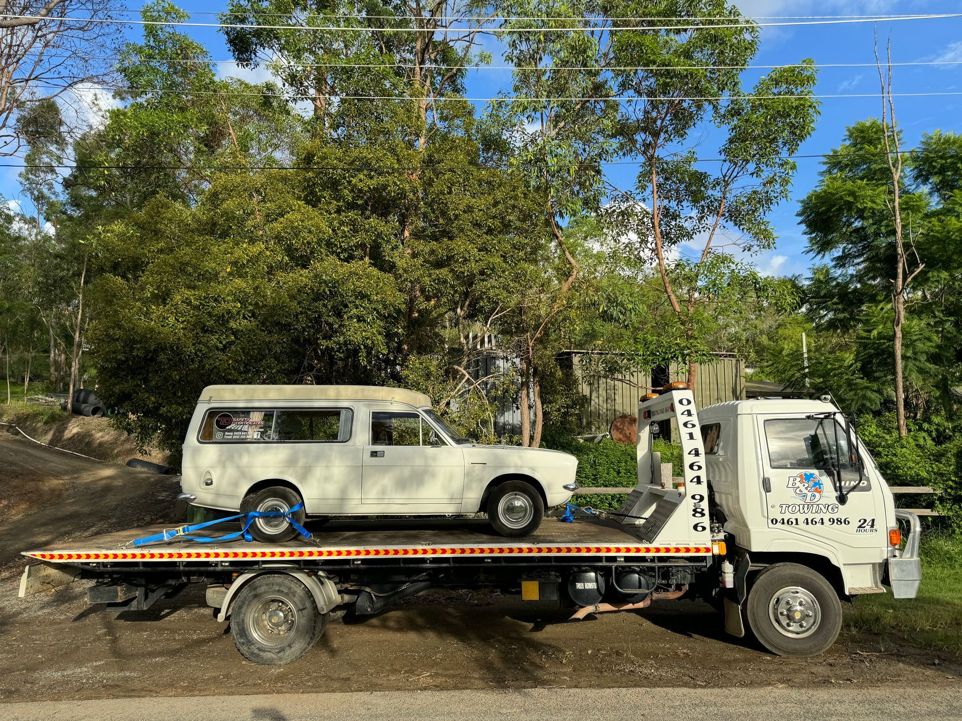 White Car Loaded on a Tow Truck, Parked on a Road With Trees in the Background — B&D Auto Group & Towing in Ayr, QLD