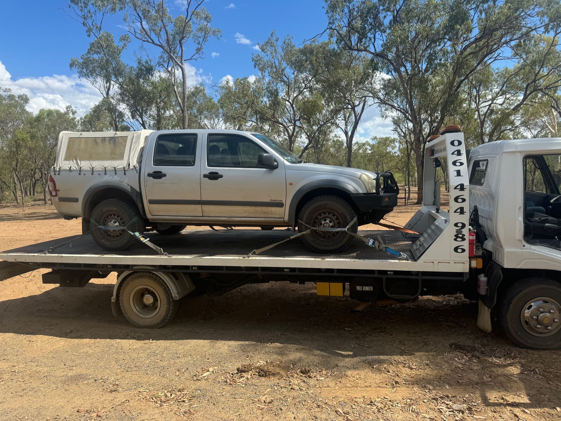 Silver Pickup Truck on a Flatbed Tow Truck in a Rural Setting — B&D Auto Group & Towing in Airlie Beach, QLD