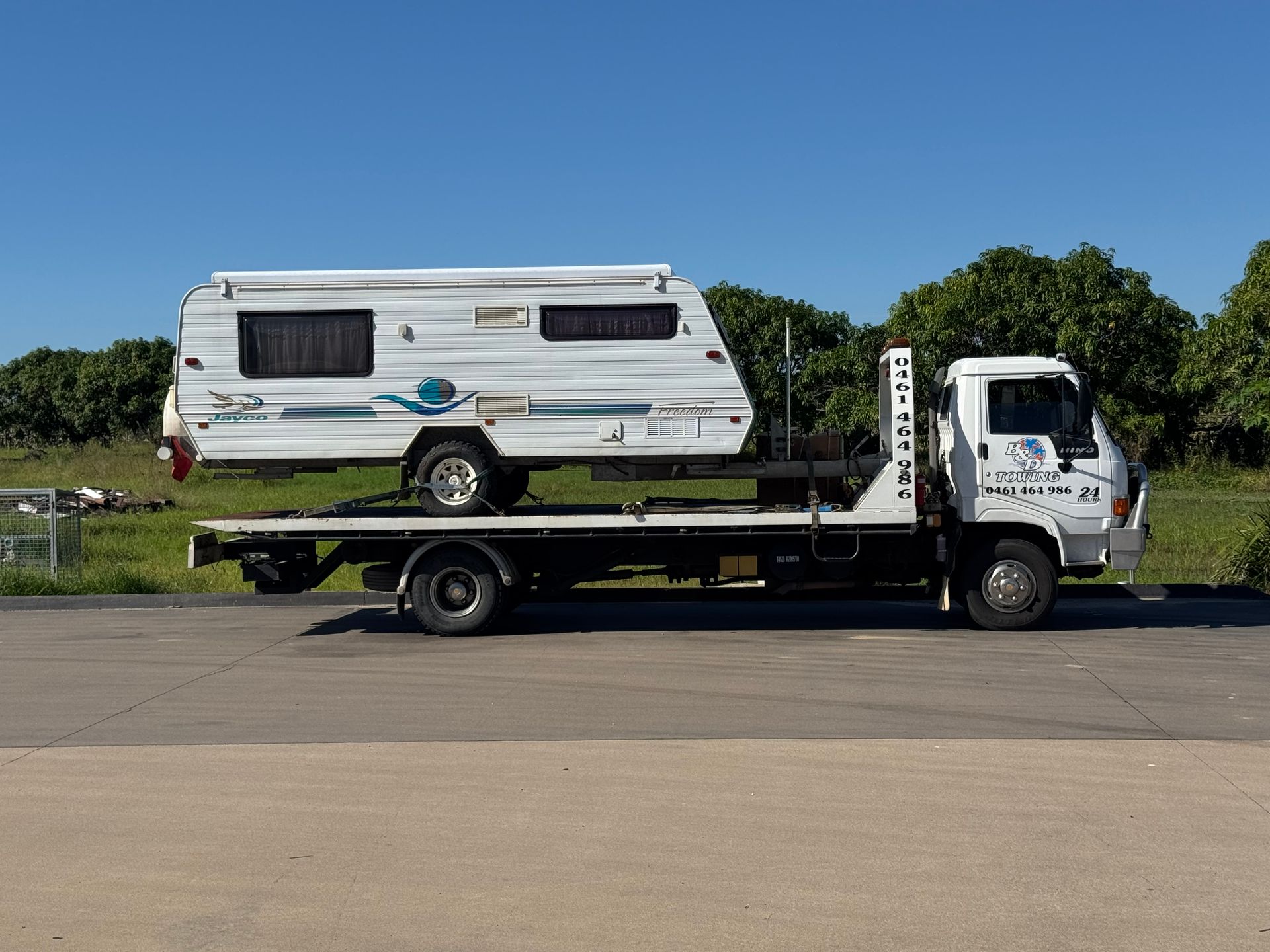 Tow Truck Carrying a White and Blue Caravan on a Flatbed — B&D Auto Group & Towing in Airlie Beach, QLD