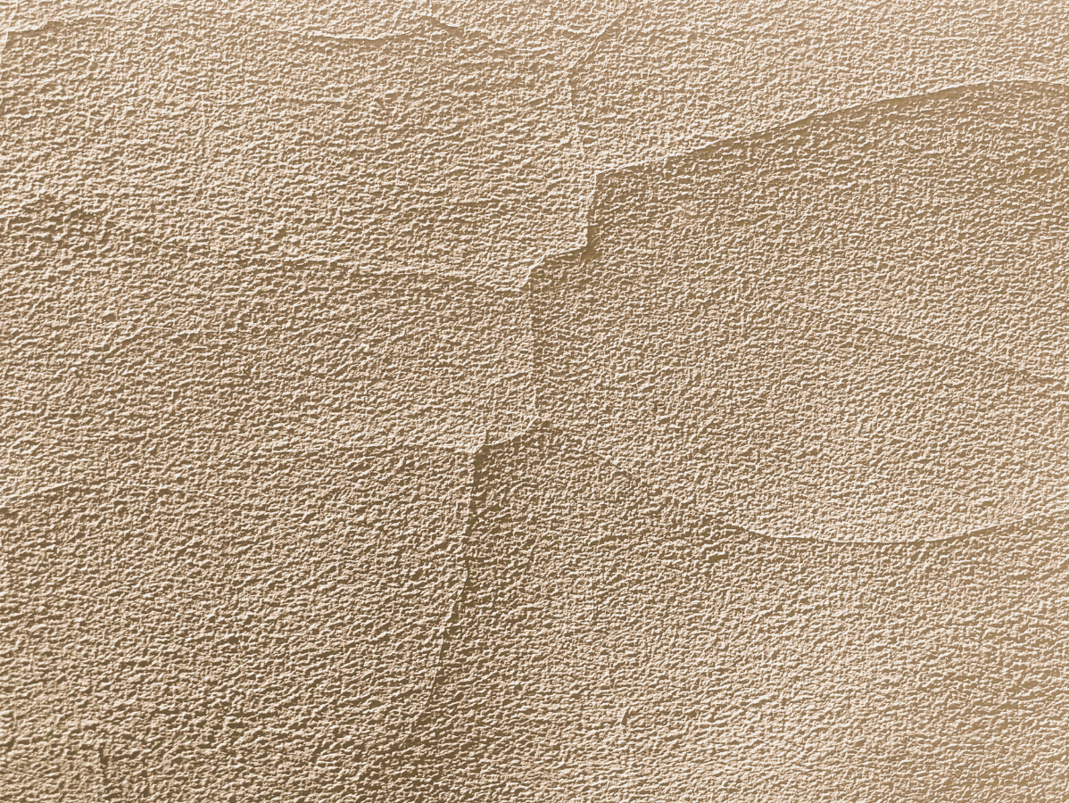 Close-up of a beige textured wall with subtle vertical seam lines