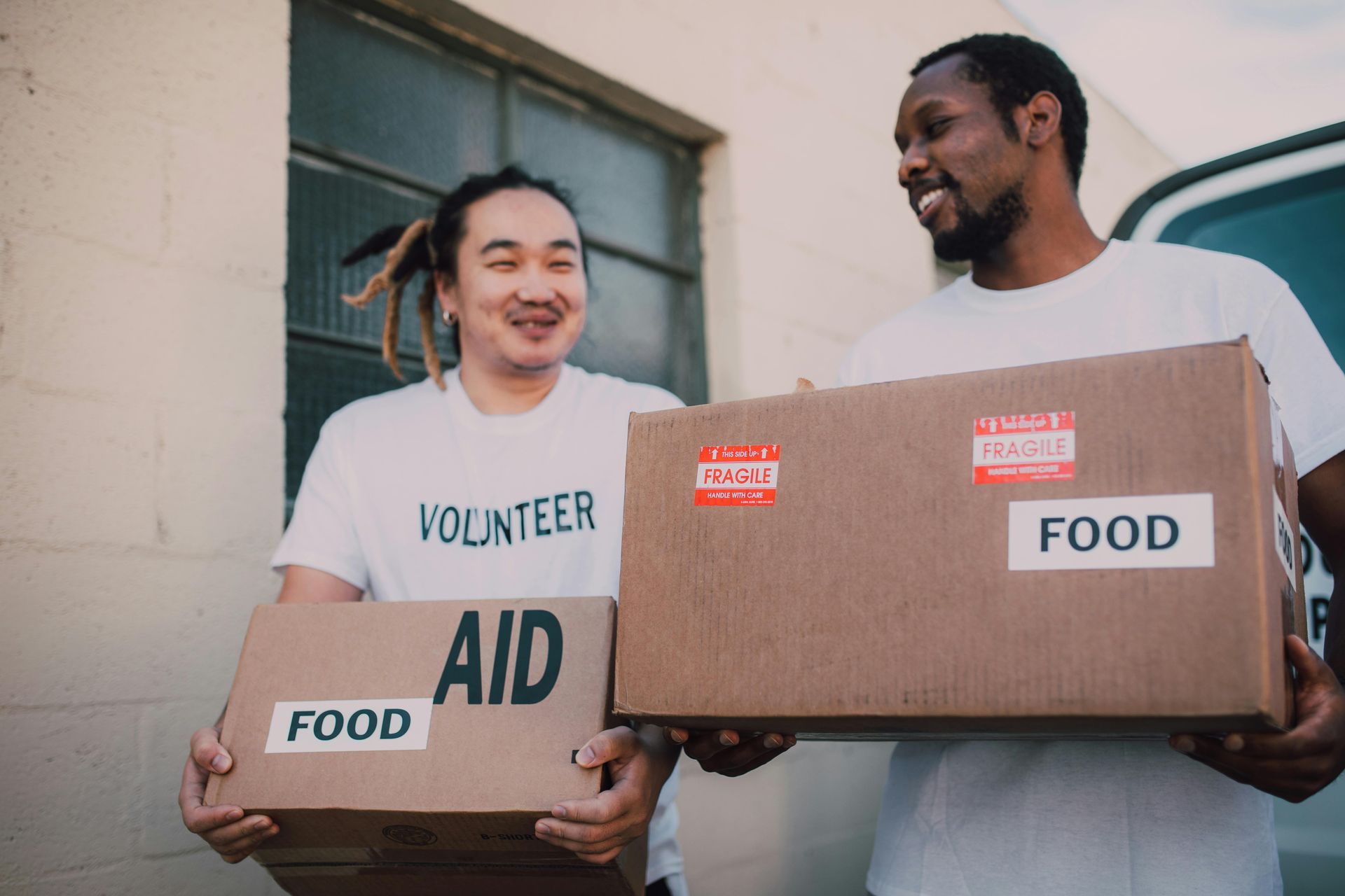 Two volunteers carry boxes. 