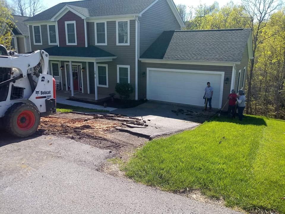 A bobcat is parked in front of a house.