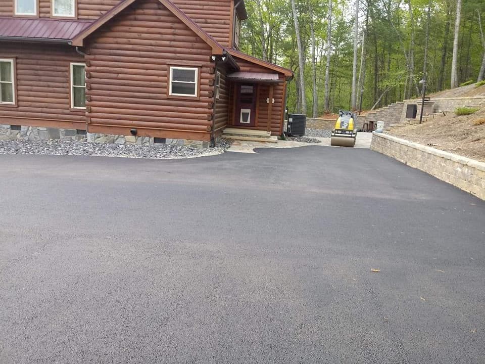 A log cabin with a new driveway in front of it