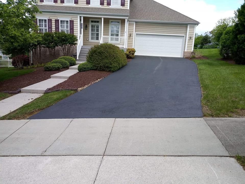 A house with a black driveway and a white garage door