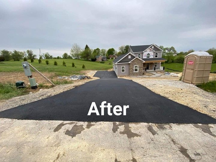 A picture of a driveway that has been paved and a house in the background.